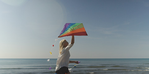 Image showing Young Woman holding kite at beach on autumn day