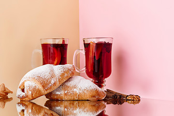 Image showing Mulled wine in glass with cinnamon stick, christmas cake on on the glass table