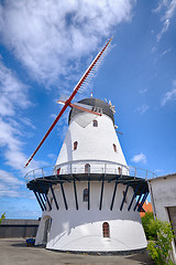 Image showing Old windmill rising up to a blue sky