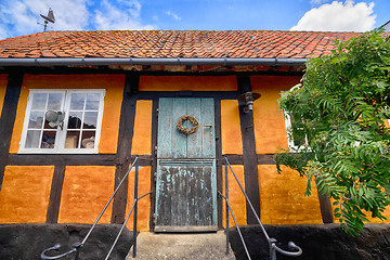 Image showing Entrance to an old orange house under a blue sky