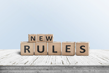 Image showing New rules sign made of wood on a desk