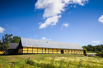 Image showing Yellow barn on a green meadow