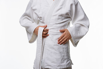 Image showing Stages of correct tying of the belt by a teenager on a sports kimono, step two