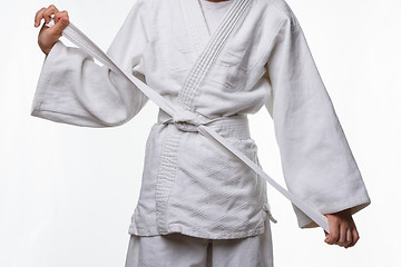 Image showing Stages of correct tying of the belt by a teenager on a sports kimono, step nine