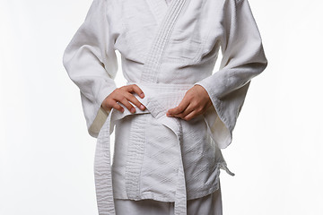 Image showing Stages of correct tying of the belt by a teenager on a sports kimono, step five