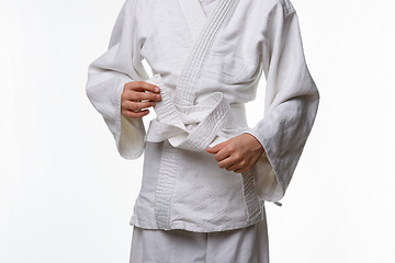 Image showing Stages of correct tying of the belt by a teenager on a sports kimono, step eight