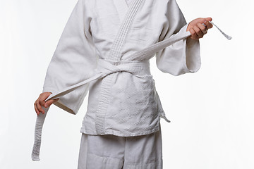 Image showing Stages of correct tying of the belt by a teenager on a sports kimono, step seven