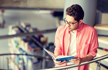 Image showing student boy or young man reading book at library