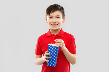 Image showing smiling boy in red t-shirt eating popcorn