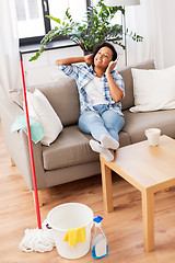 Image showing woman in headphones resting after home cleaning