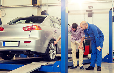 Image showing auto mechanic with clipboard and man at car shop