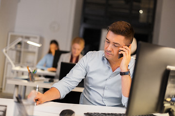 Image showing man calling on smartphone at night office