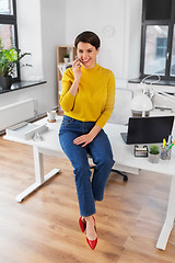 Image showing happy woman and calling on smartphone at office