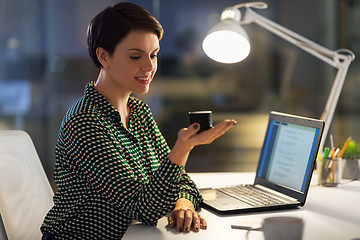 Image showing businesswoman using smart speaker at night office