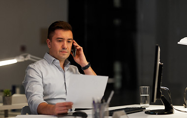 Image showing businessman calling on sartphone at night office