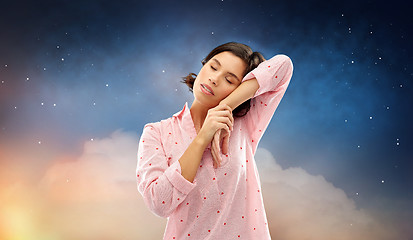 Image showing tired woman in pajama napping over night sky