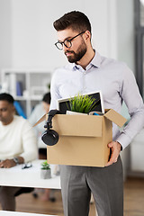 Image showing sad fired male office worker with personal stuff