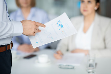 Image showing close up of businessman with charts at office