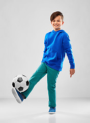 Image showing smiling boy in blue hoodie playing soccer ball