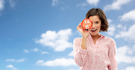 Image showing happy young woman in pajama with alarm clock