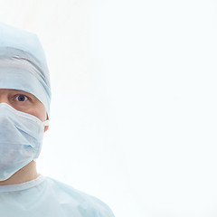 Image showing Half face of surgeon in sterile surgical mask and medical cap isolated on white