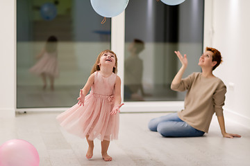 Image showing mother and cute little daughter playing with balloons