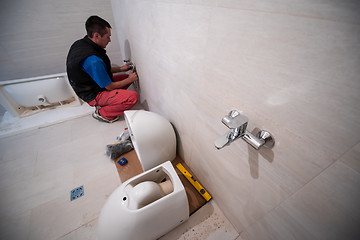 Image showing professional plumber working in a bathroom