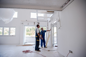 Image showing carpenters installing glass door with a wooden frame