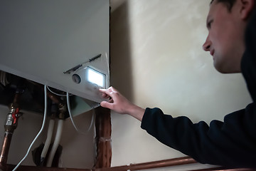 Image showing engineer checking technical data of heating system