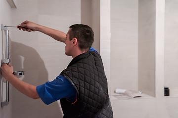 Image showing professional plumber working in a bathroom