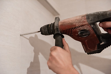 Image showing construction worker drilling holes in the bathroom