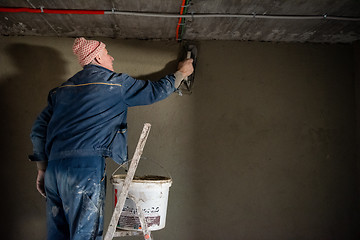 Image showing Worker plastering the wall by concrete