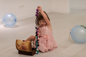 Image showing little girl enjoying while playing with mother\'s jewelry