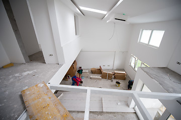 Image showing worker installing the ceramic wood effect tiles on the floor