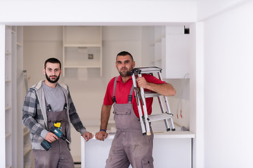 Image showing young workers installing a new kitchen