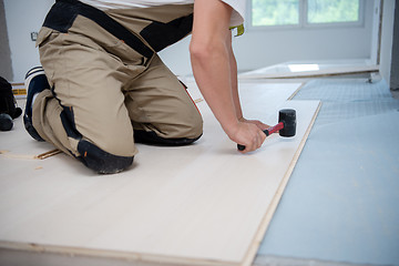 Image showing Professional Worker Installing New Laminated Wooden Floor