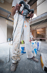 Image showing construction worker mixing plaster in bucket