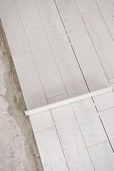 Image showing Ceramic wood effect tiles and tools for tiler on the floor