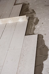 Image showing Ceramic wood effect tiles and tools for tiler on the floor