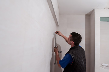 Image showing professional plumber working in a bathroom