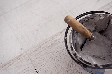 Image showing Ceramic wood effect tiles and tools for tiler on the floor