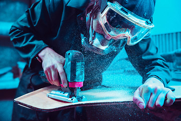 Image showing Skater in process of making his own skateboard, longboard - open business concept