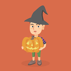 Image showing Young boy holding a carved pumpkin for Halloween.