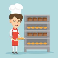 Image showing Young caucasian baker holding a tray with bread.