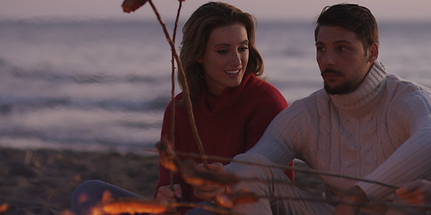 Image showing Group Of Young Friends Sitting By The Fire at beach