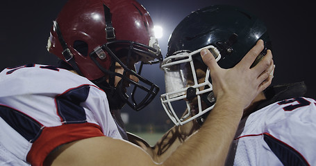 Image showing American football players knocking with helmets and having fun