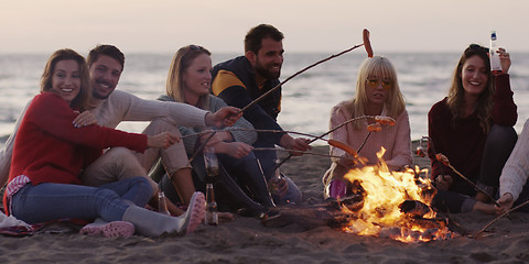 Image showing Group Of Young Friends Sitting By The Fire at beach