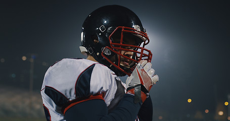 Image showing American Football Player Putting On Helmet on large stadium with