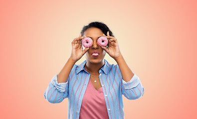 Image showing happy african american woman with eyes of donuts