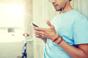 Image showing man with earphones and smartphone listening music